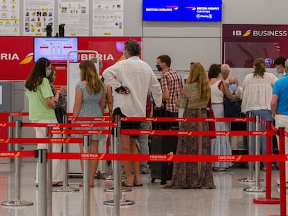 Viajeros con destino al Reino Unido hacen cola para facturar en el aeropuerto de Palma de Mallorca, este domingo.