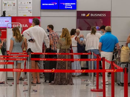 Viajeros con destino al Reino Unido hacen cola para facturar en el aeropuerto de Palma de Mallorca, este domingo.