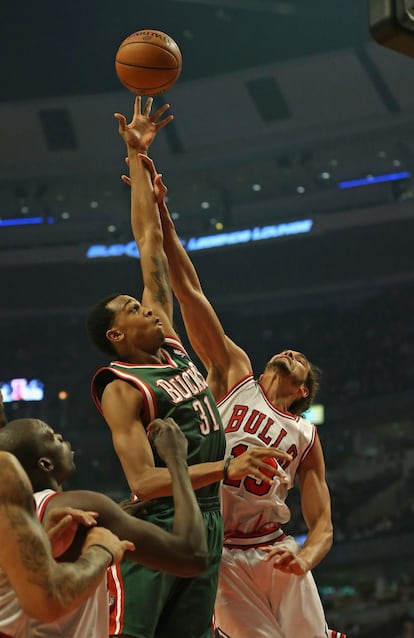 Joakim Noah intenta taponar el tiro a John Henson, de los Milwaukee Bucks.