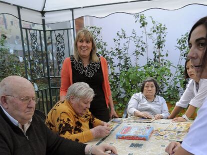 Carmen Pena (de pie) junto a los ancianos que atiende en el centro de día de Lugo.