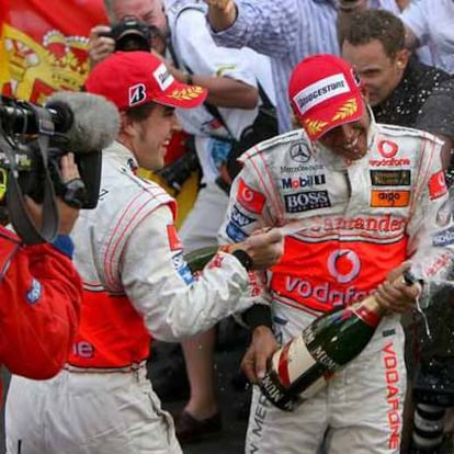Fernando Alonso riega con champán a su compañero de escudería, Lewis Hamilton, ambos en el podio del Gran Premio de Mónaco.
