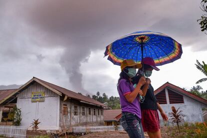 Dos jóvenes caminan mientras el volcán Sotupan sigue en erupción en Minahasa, al norte de la isla de Célebes, el 3 de octubre de 2018.  