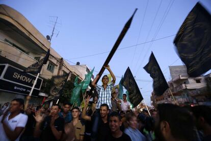 Un hombre carga con un cohete de juguete mientras se apoya en los hombros de un compañero durante las manifestaciones que festejan el anuncio del alto el fuego entre Israel y Hamás.