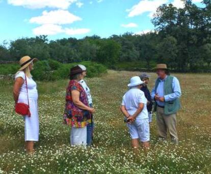 El paisajista Eduardo Mencos (con sombrero), en una pradera con un grupo de turistas.