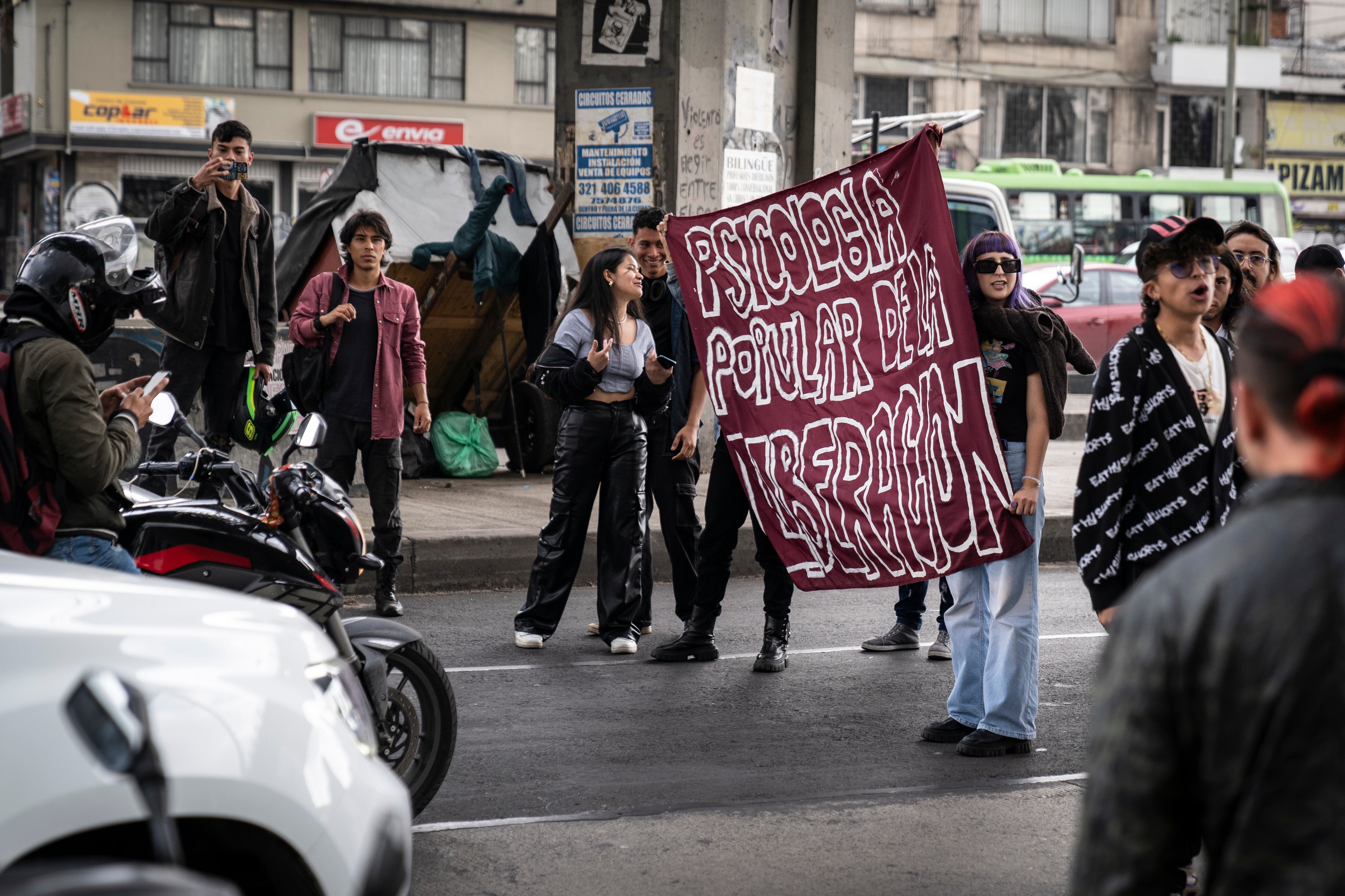 Estudiantes protestan en una vía afuera de la universidad.