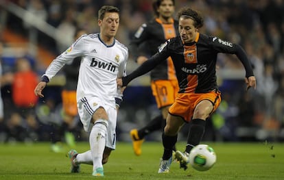 Özil pelea el balón con Guardado.