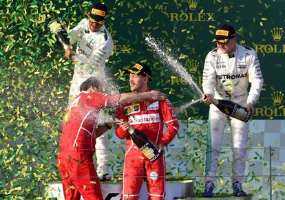 Vettel (c) celebra su victoria en el pódium con Hamilton (izquierda) y Bottas (d).
