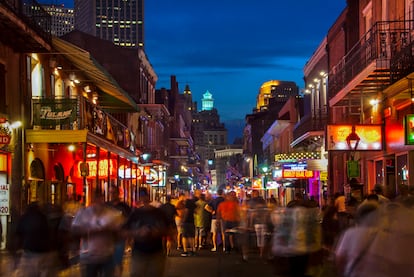 Viandantes paseando por la calle de Bourbon, repleta de bares y clubs en Nueva Orleans .