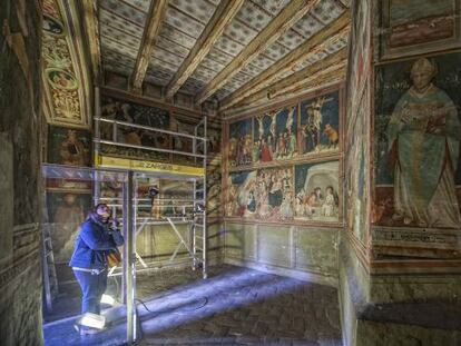 Una persona observa las pinturas de la capilla de Sant Miquel del monasterio de Pedralbes, en Barcelona.