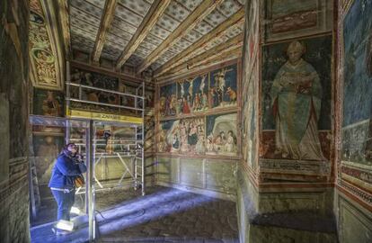 Una persona observa las pinturas de la capilla de Sant Miquel del monasterio de Pedralbes, en Barcelona.