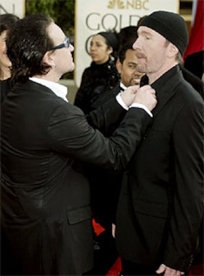 Bono y The Edge, de la banda de rock U2, bromean antes de entrar en la fiesta de la entrega de premios en Beverly Hills.