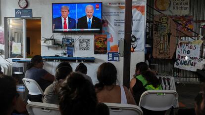 Varias personas siguen el debate en un albergue para migrantes en Tijuana (México).