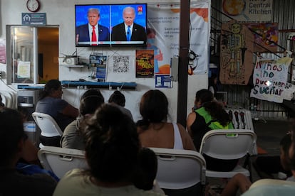 Several people follow the debate in a migrant shelter in Tijuana, Mexico.