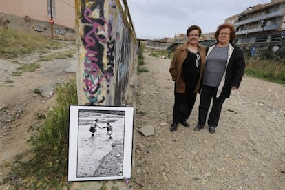 Dolores Moscoso (esquerra) i Isabel Gutiérrez al costat de la foto de les inundacions a la riera de les Arenes, dimarts.