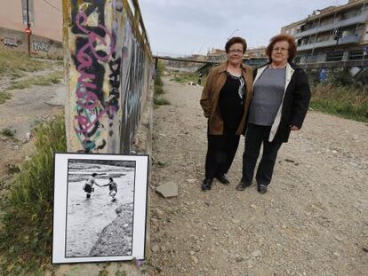 Dolores Moscoso (izquierda) e Isabel Gutiérrez posan junto a la foto de las inundaciones en la riera de las Arenas, el martes.