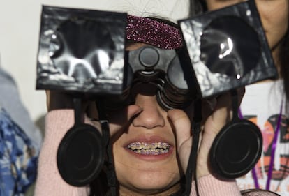 Una mujer prueba unos prismáticos modificados para poder observar el eclipse cerca de Central Park, en La Higuera (Chile), el 'epicentro' del fenómeno.