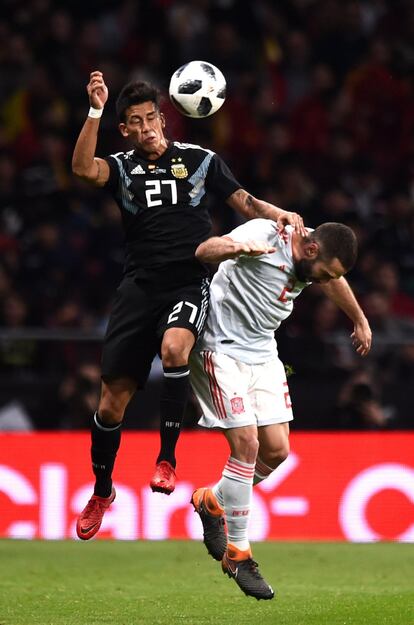 Maximiliano Meza, de la selección de Argentina, compite por el balón junto Carvajal.