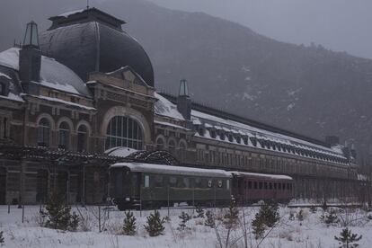 Vista exterior de la estación de Canfranc con dos vagones restaurados.