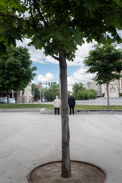 Dos personas mayores en la Plaza de Colón, separados por la distancia de seguridad, a finales de mayo.