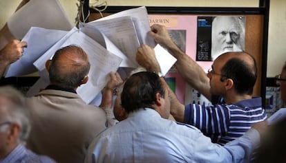 Varias personas consultan el censo antes de votar en Valencia.