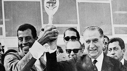 Carlos Alberto levanta a taça de campeão com o ditador Emílio Médici.