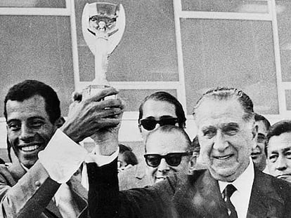 Carlos Alberto levanta a taça de campeão com o ditador Emílio Médici.