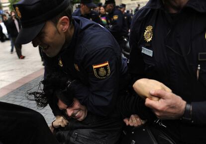 Un activista forcejea con la policía tras ser desalojado.