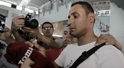 El nuevo portero del Real Madrid, Keylor Navas, firma autógrafos a unos aficionados este domingo en el aeropuerto.