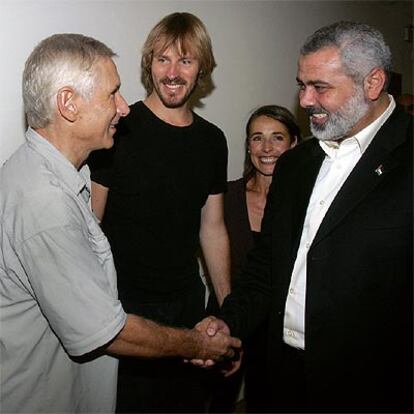 El primer ministro palestino, Ismail Haniya (derecha), saluda a los dos reporteros liberados.