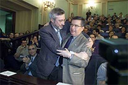 Francisco Tomás, a la derecha, recibe el abrazo del rector saliente, Pedro Ruiz.
