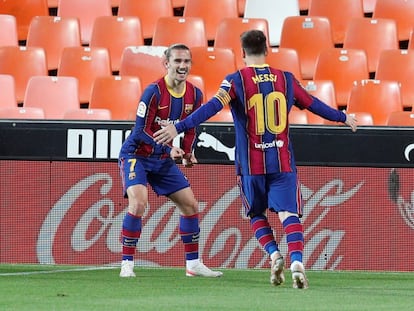 Messi y Griezmann festejan un gol al Valencia en el último duelo liguero.