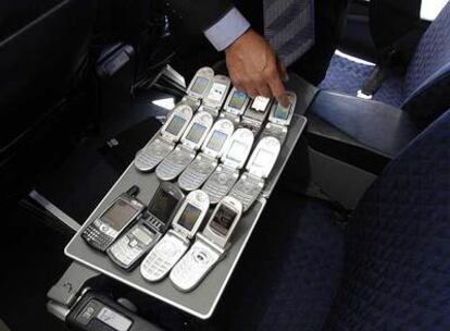 Un técnico manipula teléfonos móviles durante una prueba para su uso en aviones.
