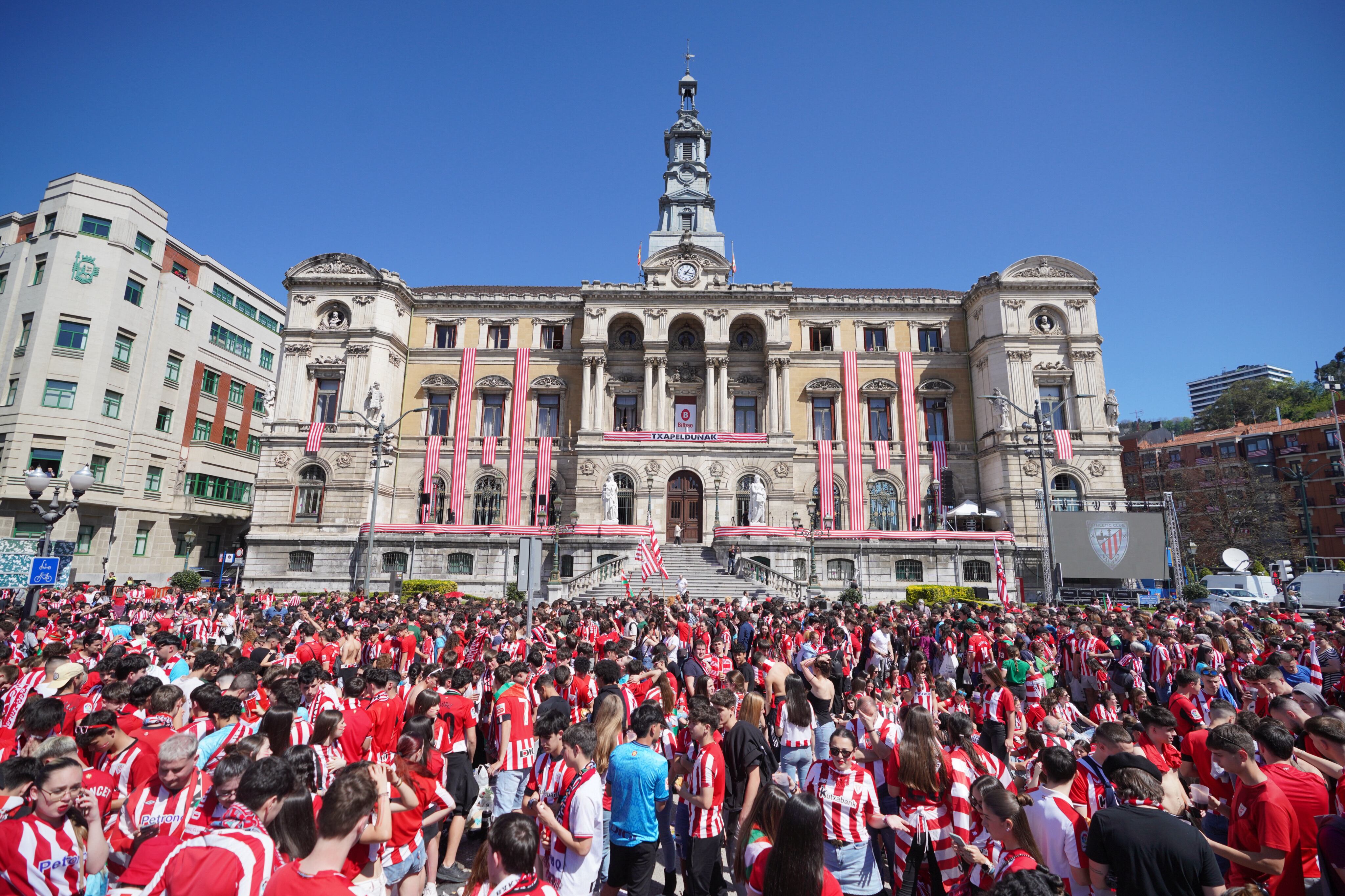 Cientos de aficionados del Athletic Club de Bilbao esperan la llegada del equipo al Ayuntamiento de Bilbao, este jueves. 