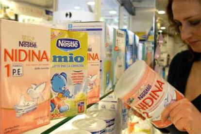Una cliente de un supermercado de Santander muestra leches infantiles de Nestlé.