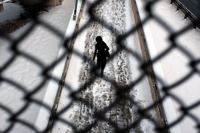 A woman walks across a bridge during frigidly cold weather on February 17, 2015 in Brooklyn borough of New York City. With temperatures in the teens and the wind chill making it feel below zero, New York City is experiencing some of its coldest weather in years. Spencer Platt/Getty Images/AFP == FOR NEWSPAPERS, INTERNET, TELCOS & TELEVISION USE ONLY ==