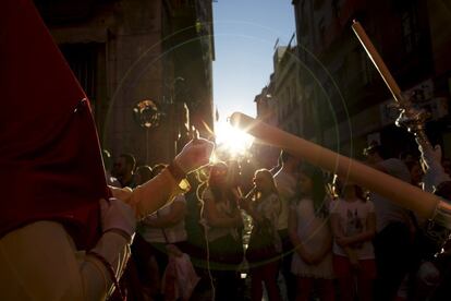 Un penitente de la hermandad de La Lanzada enciende un cirio durante la procesión por las calles de Sevilla, el 1 de abril de 2015.