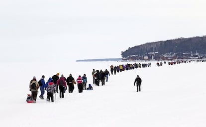 Decenas de turistas cruzan a pie el lago en dirección a las cuevas de hielo, en las islas Apostle.