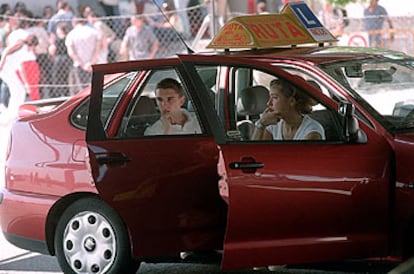 Unos jóvenes esperan un examen práctico del carné de conducir.