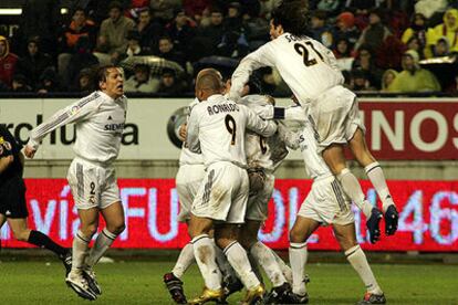 Los jugadores del Madrid se lanzan sobre Helguera para festejar su gol, el de la victoria.