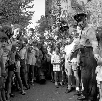 Una multitud de niños y dos policías en la fiesta mayor de la Barceloneta, en 1970, en una imagen de Pere Català i Roca.