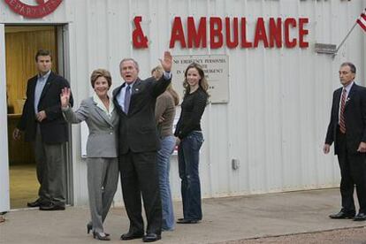 El presidente Bush, junto a su esposa y sus hijas, saluda antes de entrar en el parque de bomberos de Crawford (Tejas) para depositar su voto.