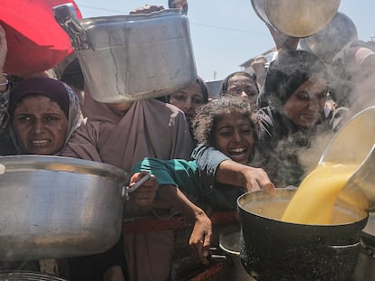 Unos niños palestinos aguardan un reparto de comida de una organización caritativa en Ciudad de Gaza, el 4 de agosto.