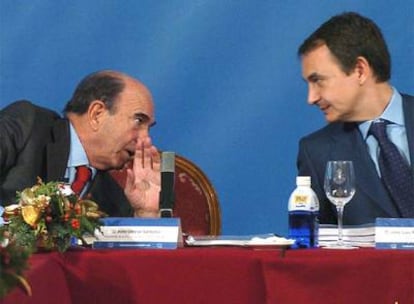 Botín, tapándose la boca, le hace comentarios a Rodríguez Zapatero en un acto de la Fundación de Estudios Financieros en 2005.