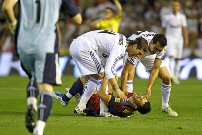 Sergio Ramos y Arbeloa levantan a Villa del césped mientras este se queja por una entrada del segundo.