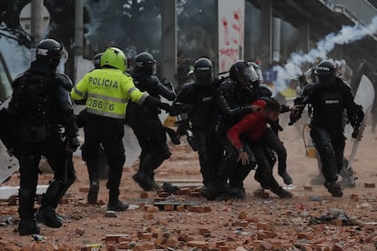 Policías antidisturbios retienen a un manifestante durante una jornada de protestas en Colombia