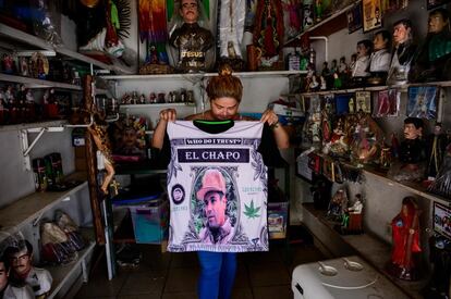 Una vendedora muestra una camiseta con el retrato del narcotraficante mexicano Joaquín El Chapo Guzmán en una tienda al lado de la capilla del narco Jesús Malverde en Culiacán (México), el 15 de julio de 2019. Este miércoles la justicia de EE UU condenó a El Chapo a cadena perpetua por narcotráfico. El tribunal de Nueva York dictó también 30 años por violencia con armas y 20 por blanqueo de dinero.