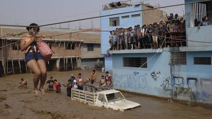 Una mujer es trasladada en un arnés a causa de las inundaciones en Lima, Perú.