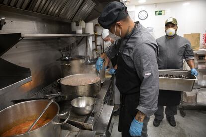 Varios cocineros preparan comida para llevar en un restaurante de Madrid.