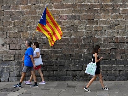 Dos manifestantes a favor de la independencia de Cataluña con una bandera "estelada", durante la Diada, el 11 de septiembre de 2022.