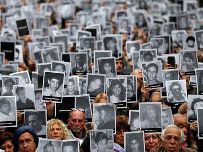 Cientos de personas levantan las fotografías de las 85 víctimas del atentado contra la mutua AMIA en 1994, durante una concentración en la sede de la Asociación de Mutuales Israelitas Argentinas (AMIA), en el barrio porteño de Once, en Buenos Aires (Argentina).